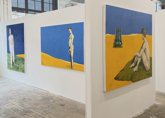 Installation view: three large beachscape paintings with male figures arranged around a central partition.